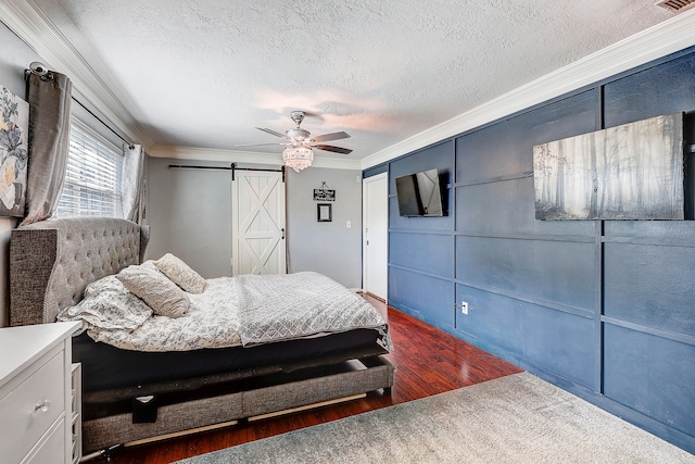 5111 Rockland Dr, Pearland, TX 77584 - bedroom featuring ornamental molding, a barn door, a textured ceiling, wood finished floors, and ceiling fan