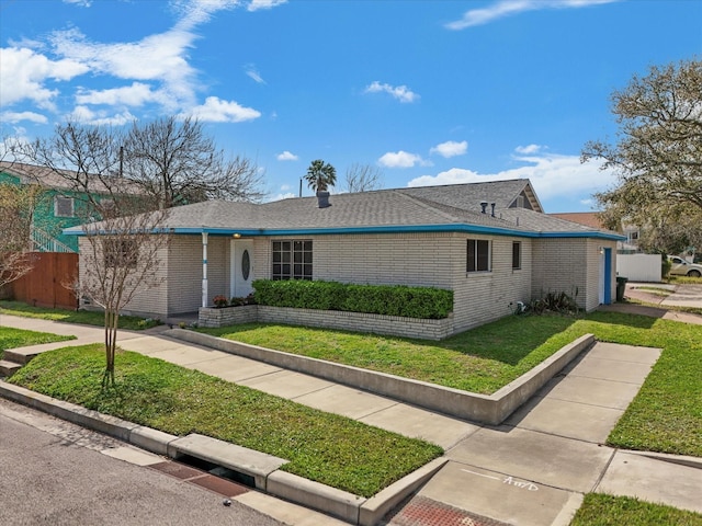 1901 49th St, Galveston, TX 77551 - ranch-style house with fence, a shingled roof, a front lawn, and brick siding