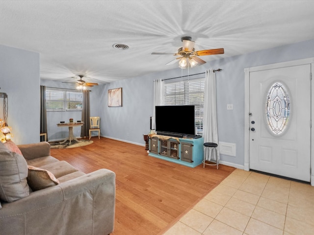 1901 49th St, Galveston, TX 77551 - living room with baseboards, a ceiling fan, light wood finished floors, and visible vents