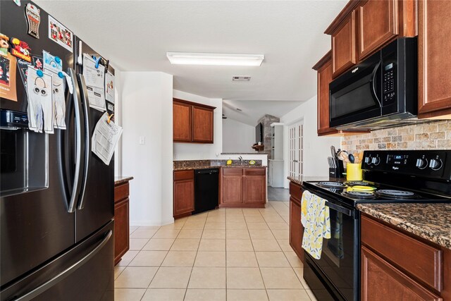 kitchen featuring tasteful backsplash, vaulted ceiling, visible vents, black appliances, and light tile patterned floors