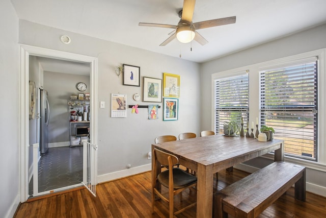dining space with baseboards, a ceiling fan, and wood finished floors