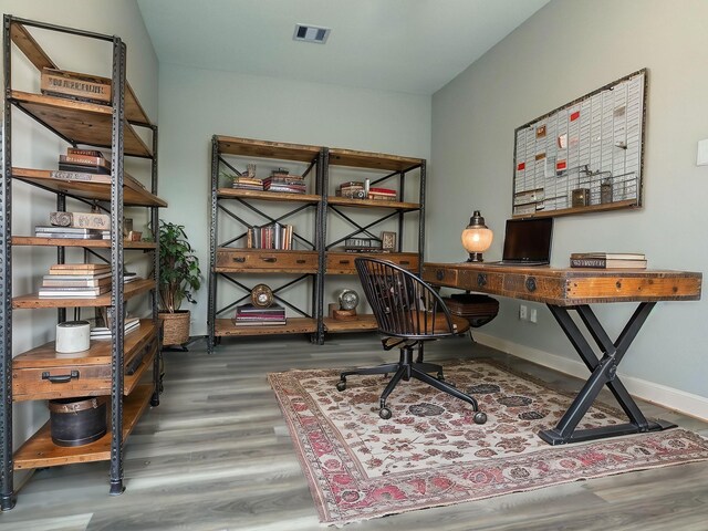 1106 Adele St, Houston, TX 77009 - home office with visible vents, wood finished floors, and baseboards