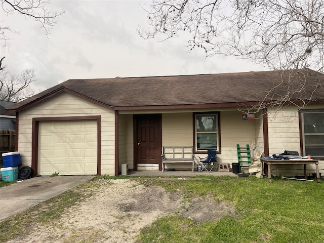 ranch-style home with roof with shingles, covered porch, concrete driveway, a garage, and a front yard