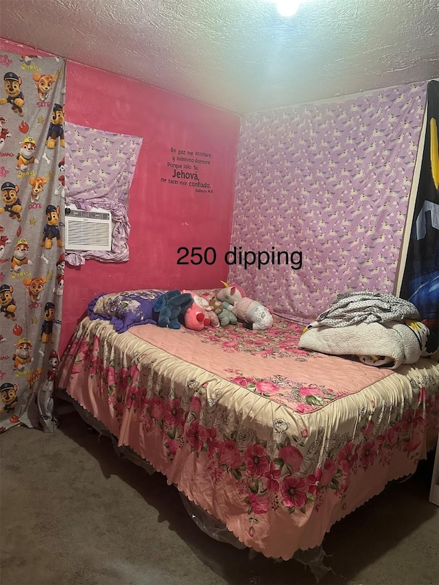 bedroom with an AC wall unit and a textured ceiling