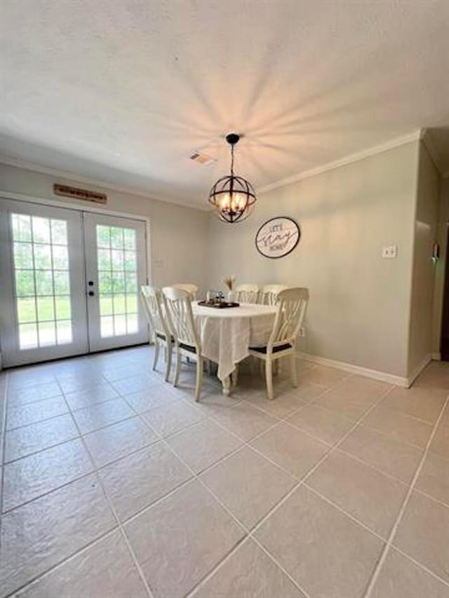 dining space with french doors, ornamental molding, and light tile patterned flooring