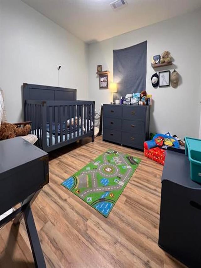 bedroom with visible vents and wood finished floors