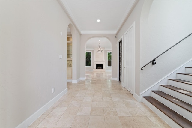 corridor featuring recessed lighting, stairway, ornamental molding, arched walkways, and a notable chandelier