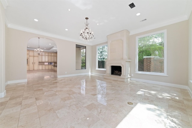 unfurnished living room featuring a chandelier, arched walkways, a wealth of natural light, and ornamental molding