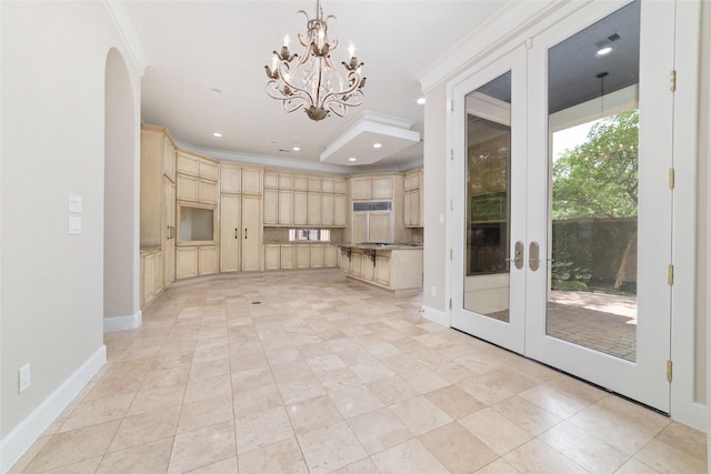 kitchen with baseboards, light brown cabinetry, a chandelier, and crown molding