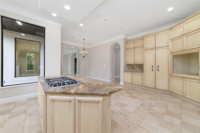 kitchen featuring stainless steel gas cooktop, light brown cabinetry, arched walkways, stone counters, and ornamental molding