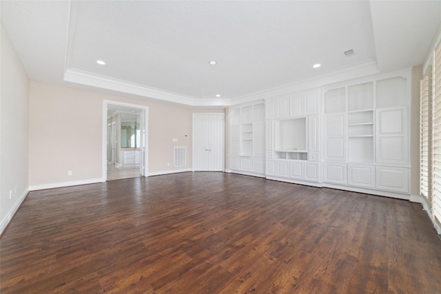 unfurnished living room with dark wood-style floors, baseboards, a tray ceiling, and visible vents