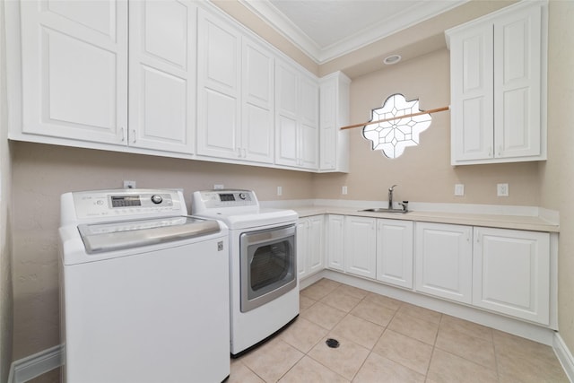 laundry room with a sink, ornamental molding, cabinet space, washer and dryer, and light tile patterned floors