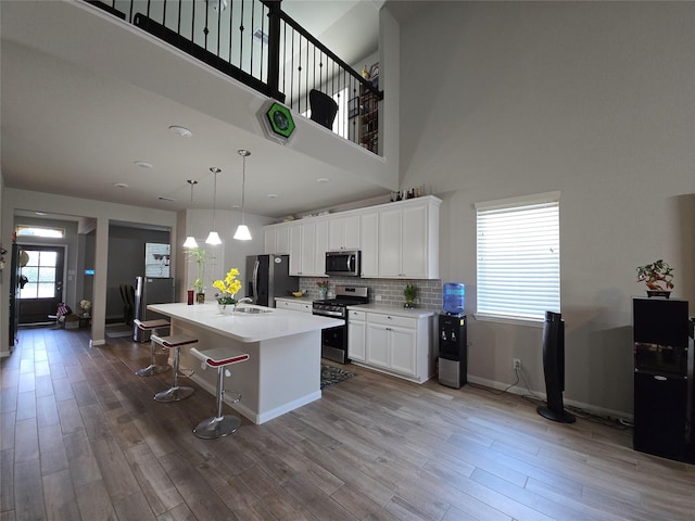 19210 Palfrey Prairie Trl, Tomball, TX 77377 - kitchen with a sink, appliances with stainless steel finishes, white cabinets, and wood finished floors