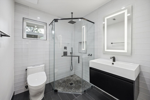 10134 Eddystone Dr, Houston, TX 77043 - full bath featuring a stall shower, vanity, tile walls, toilet, and tile patterned flooring