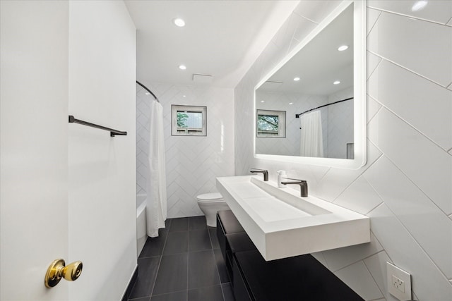 10134 Eddystone Dr, Houston, TX 77043 - bathroom featuring tile patterned floors, toilet, tile walls, recessed lighting, and vanity