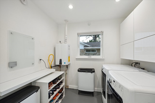 10134 Eddystone Dr, Houston, TX 77043 - laundry room featuring tankless water heater, baseboards, recessed lighting, independent washer and dryer, and cabinet space