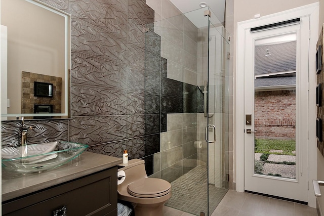 bathroom featuring tile patterned floors, vanity, a shower stall, and toilet