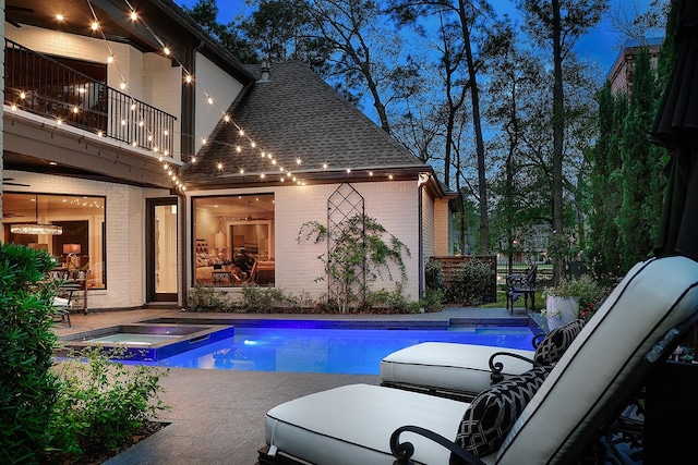 view of pool with a patio and a pool with connected hot tub