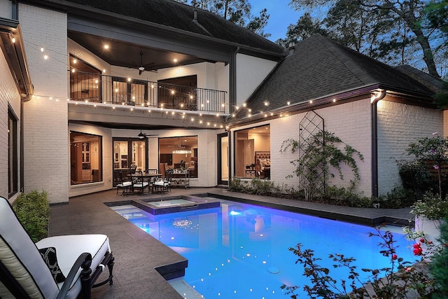 view of swimming pool featuring a ceiling fan, a pool with connected hot tub, a patio, and outdoor dining area