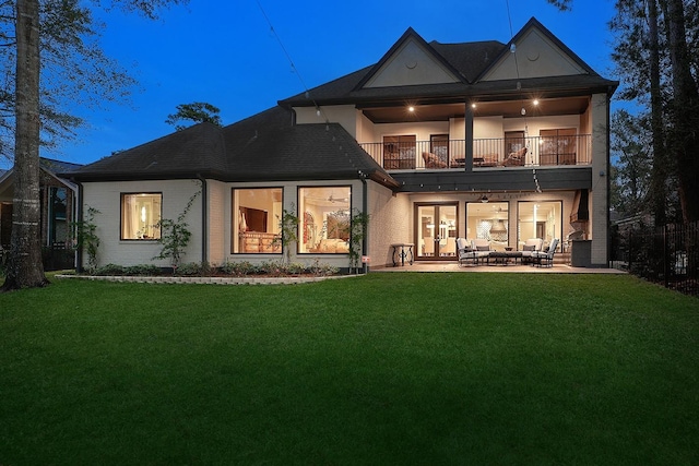 back of property featuring french doors, a patio area, a lawn, a balcony, and an outdoor hangout area