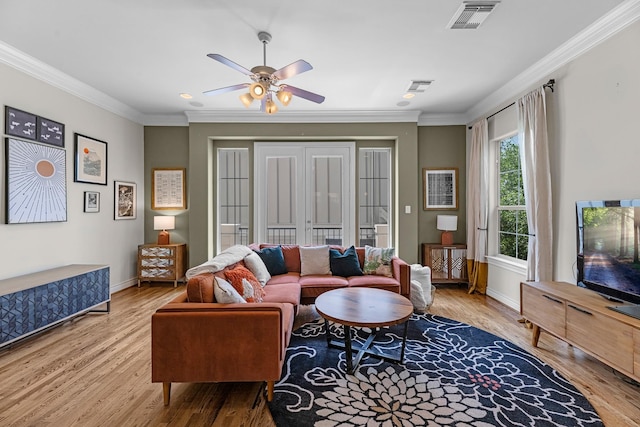 living area featuring baseboards, crown molding, wood finished floors, and visible vents