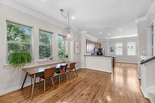 kitchen featuring light wood finished floors, dark countertops, ornamental molding, freestanding refrigerator, and baseboards