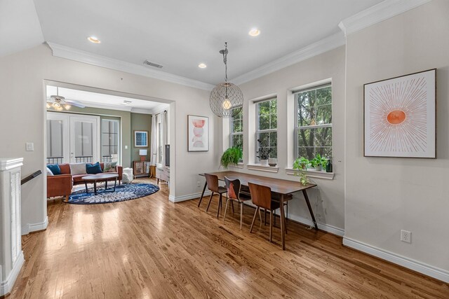 dining space with wood finished floors, baseboards, and ornamental molding