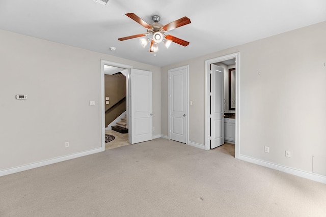 unfurnished bedroom featuring a ceiling fan, baseboards, light carpet, and connected bathroom