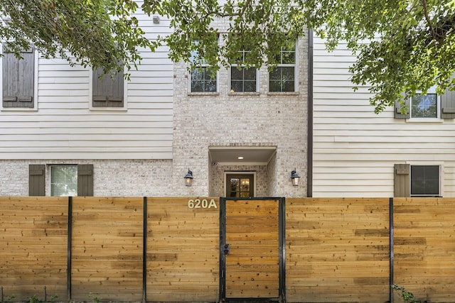 exterior space featuring brick siding and fence