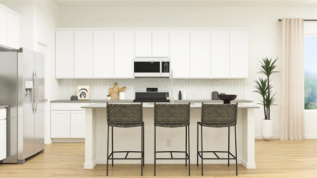 kitchen with stainless steel refrigerator with ice dispenser, range, white microwave, and light wood-style flooring