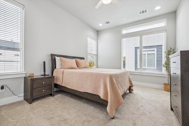 bedroom with baseboards, visible vents, a ceiling fan, and light colored carpet