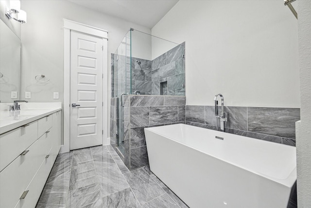 full bath with a shower stall, marble finish floor, a freestanding bath, vanity, and tile walls