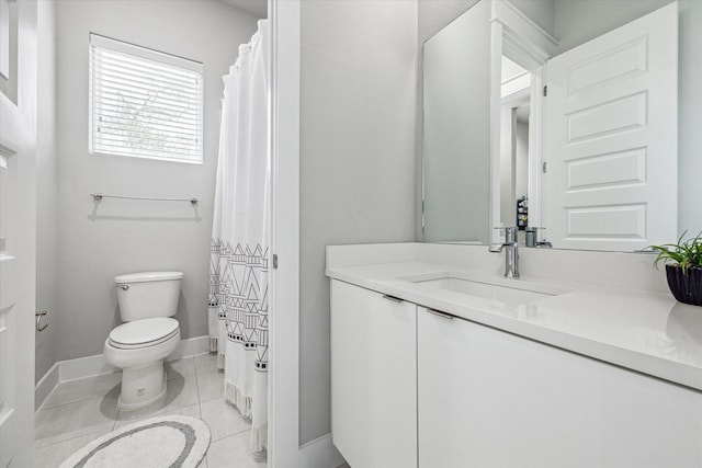 bathroom featuring baseboards, vanity, tile patterned floors, and toilet