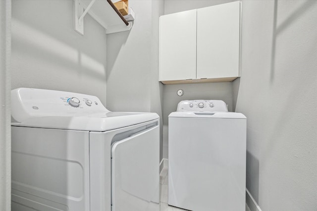 washroom with cabinet space and washer and clothes dryer