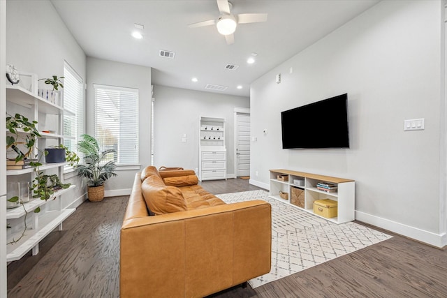 living room featuring ceiling fan, baseboards, wood finished floors, and visible vents