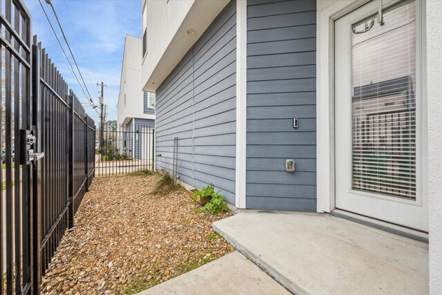 view of property exterior with fence and a gate