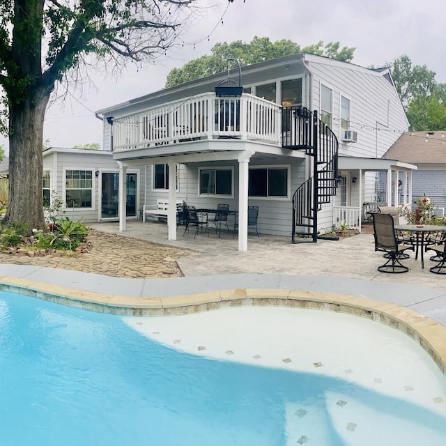 15907 Whispering Falls Ct, Houston, TX 77084 - back of property featuring stairs, an outdoor pool, a patio, and a wooden deck