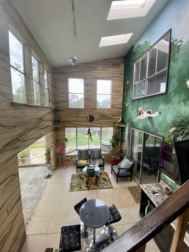 15907 Whispering Falls Ct, Houston, TX 77084 - tiled living area with high vaulted ceiling, a skylight, and wooden walls