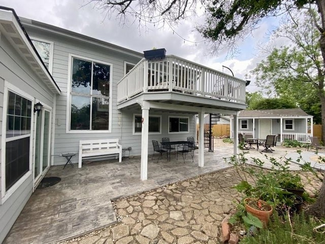 15907 Whispering Falls Ct, Houston, TX 77084 - rear view of house with a patio, an outbuilding, a wooden deck, and outdoor dining area