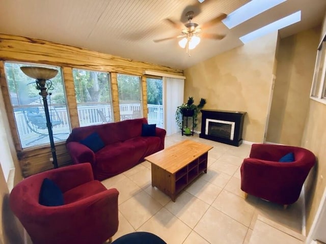 15907 Whispering Falls Ct, Houston, TX 77084 - living area featuring a ceiling fan, lofted ceiling, a fireplace, light tile patterned floors, and a skylight