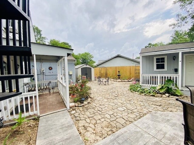 15907 Whispering Falls Ct, Houston, TX 77084 - view of patio with a storage shed, an outbuilding, fence, and a porch
