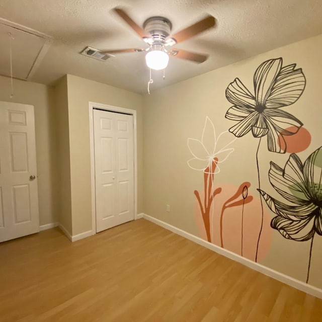 15907 Whispering Falls Ct, Houston, TX 77084 - unfurnished bedroom featuring attic access, light wood-style flooring, baseboards, and a textured ceiling