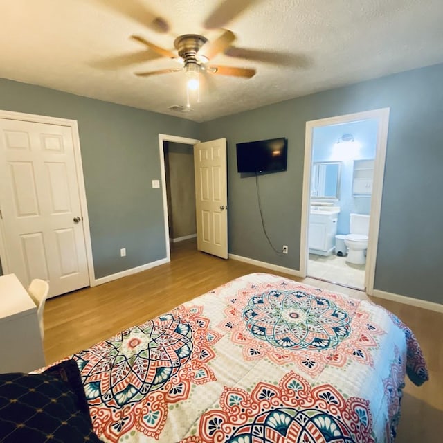15907 Whispering Falls Ct, Houston, TX 77084 - bedroom featuring wood finished floors, baseboards, ensuite bath, and a ceiling fan