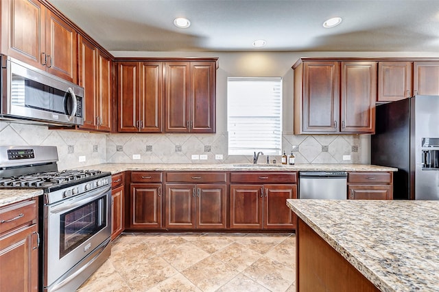 kitchen with tasteful backsplash, a sink, stainless steel appliances, light stone countertops, and recessed lighting