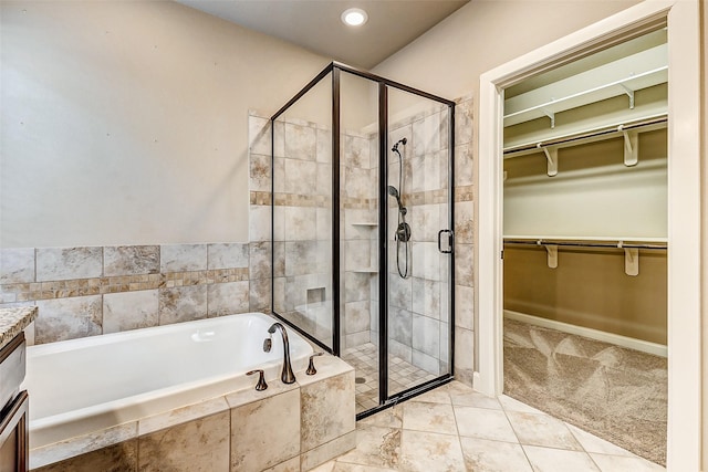 full bathroom featuring a garden tub, tile patterned flooring, a shower stall, and a walk in closet