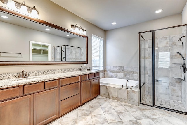 bathroom featuring a bath, a sink, double vanity, and a stall shower