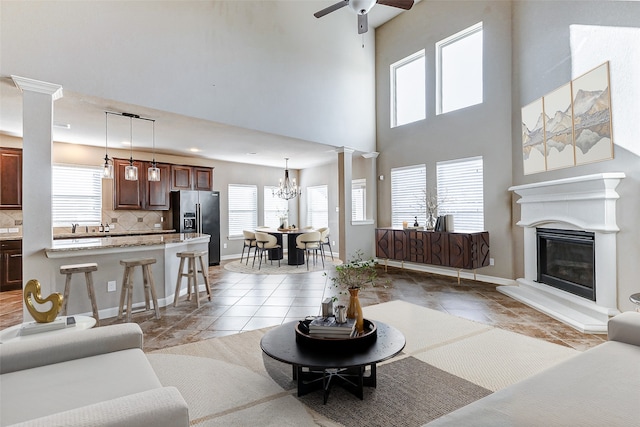 living area featuring a glass covered fireplace, a high ceiling, and a healthy amount of sunlight