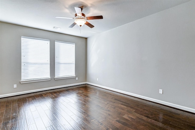 spare room with ceiling fan, baseboards, visible vents, and dark wood-style floors