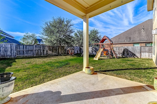 view of yard featuring a fenced backyard, a patio, and a playground