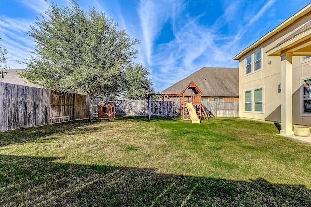 view of yard with a fenced backyard and a playground